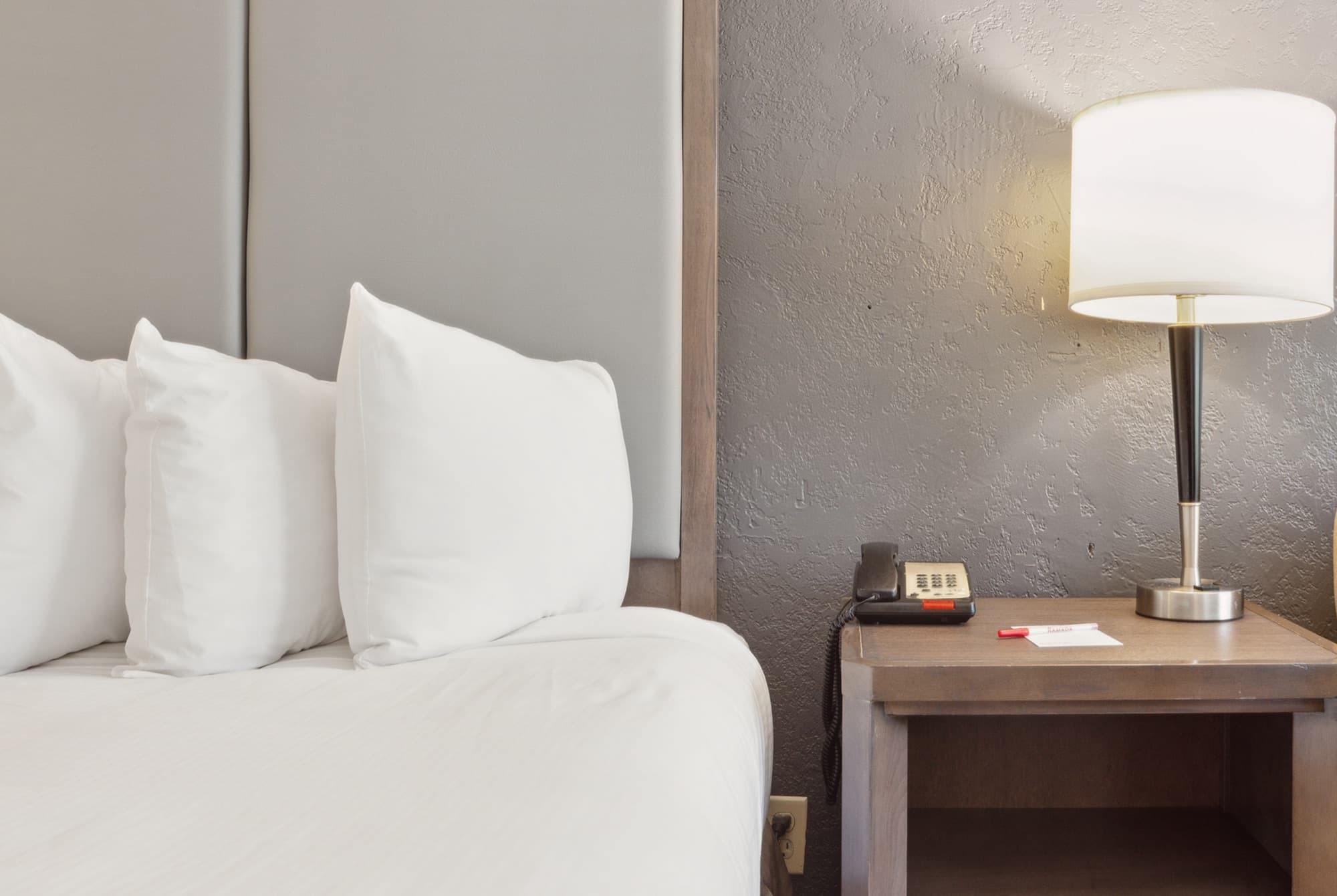 Close-up of plump white pillows and a bedside lamp