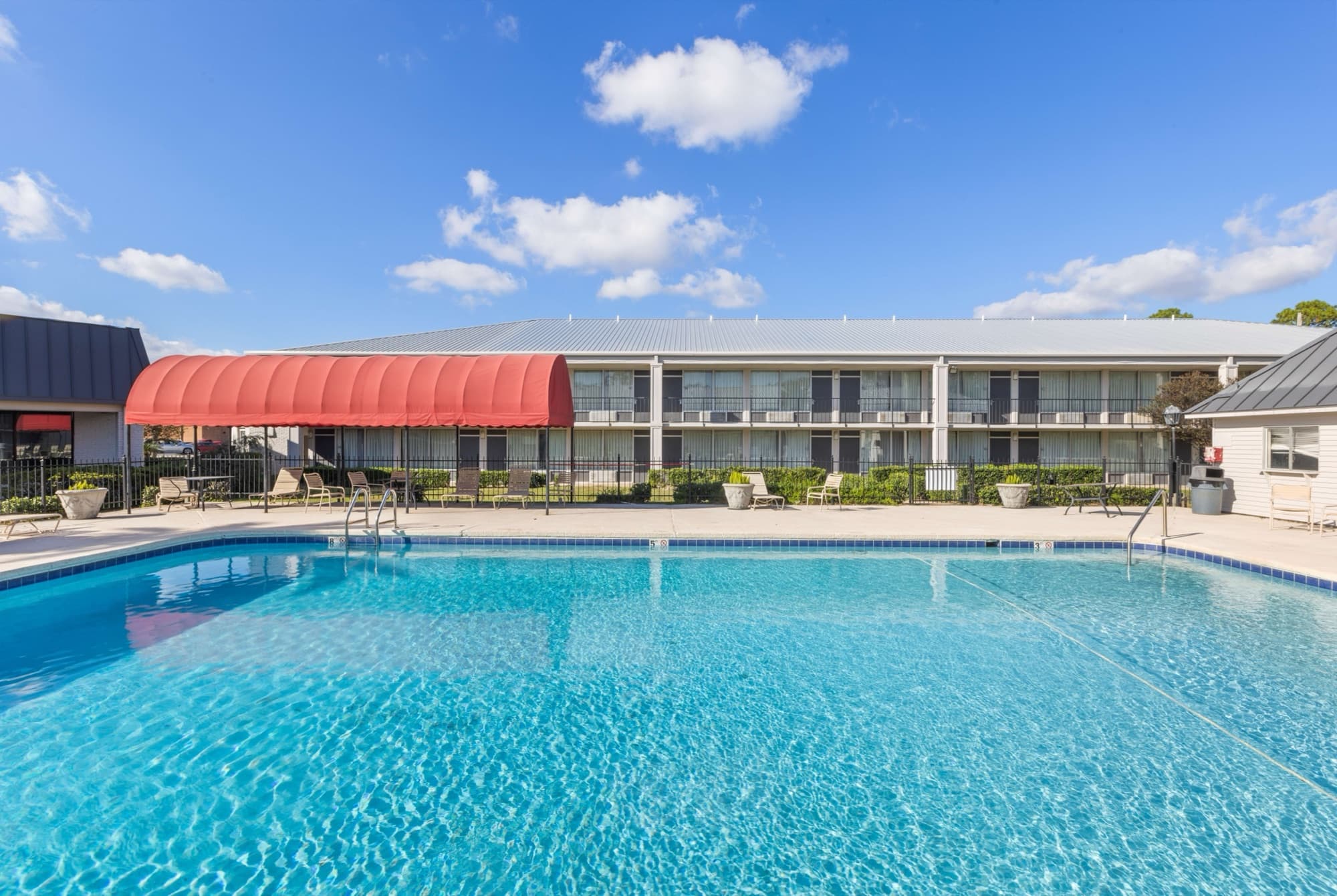 The outdoor pool at Amity Hotel & Suites with the two-storey guest wing behind it