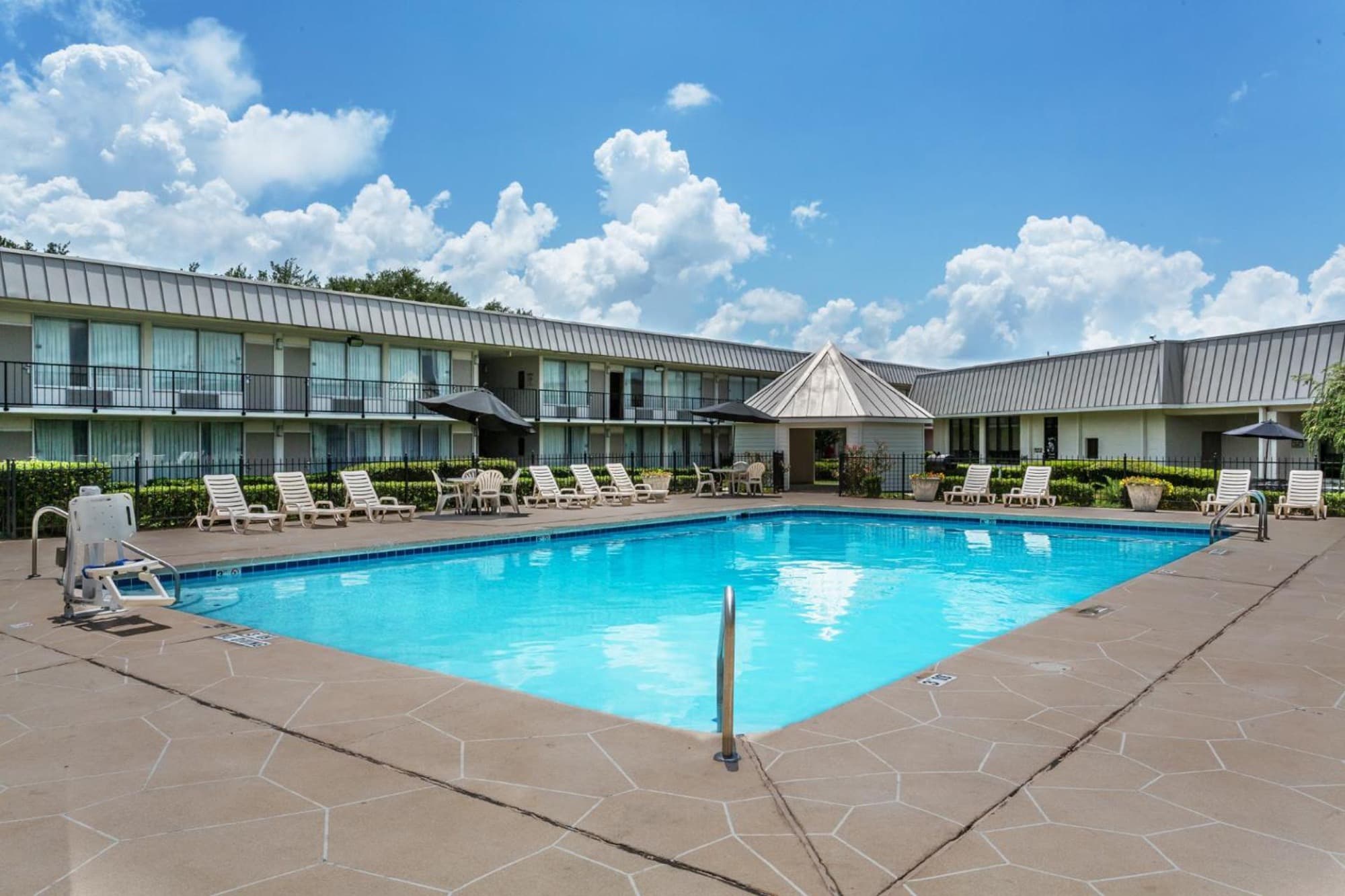 Wide view of the pool and sun deck on a clear day