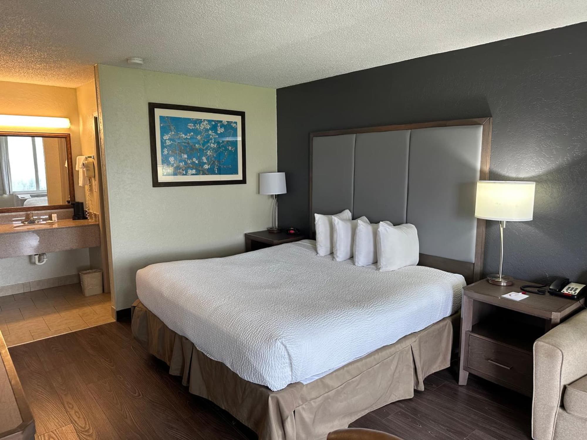 King bed against a charcoal feature wall with reading lamps