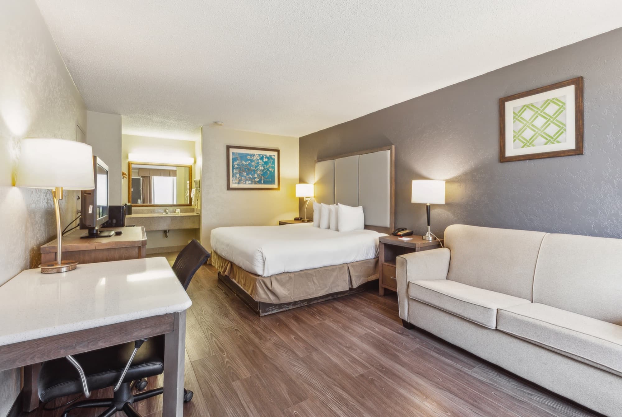 Suite with a king bed and a separate seating area with a sofa